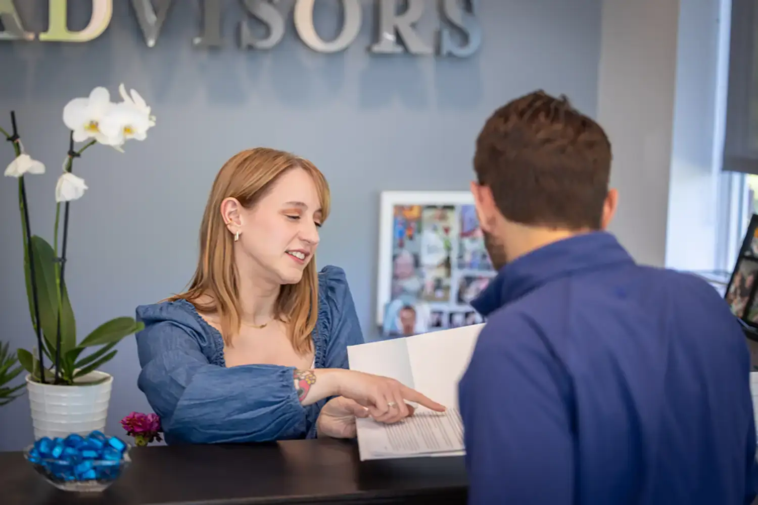 waterford employees exchanging a folder of client information at the front desk